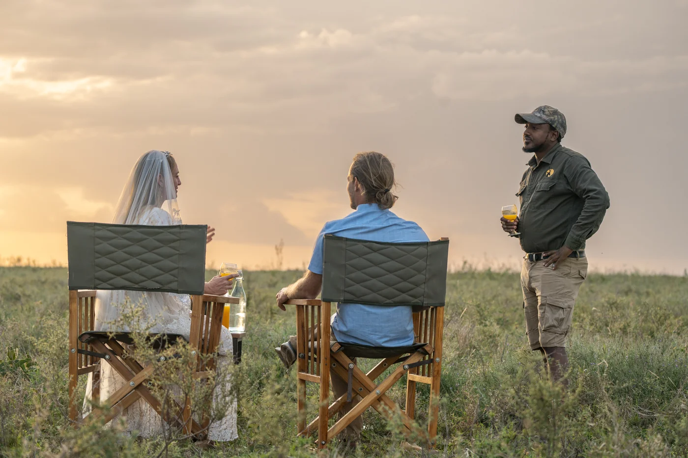 Travellers enjoying a sundowner with their guide on the Serengeti plains